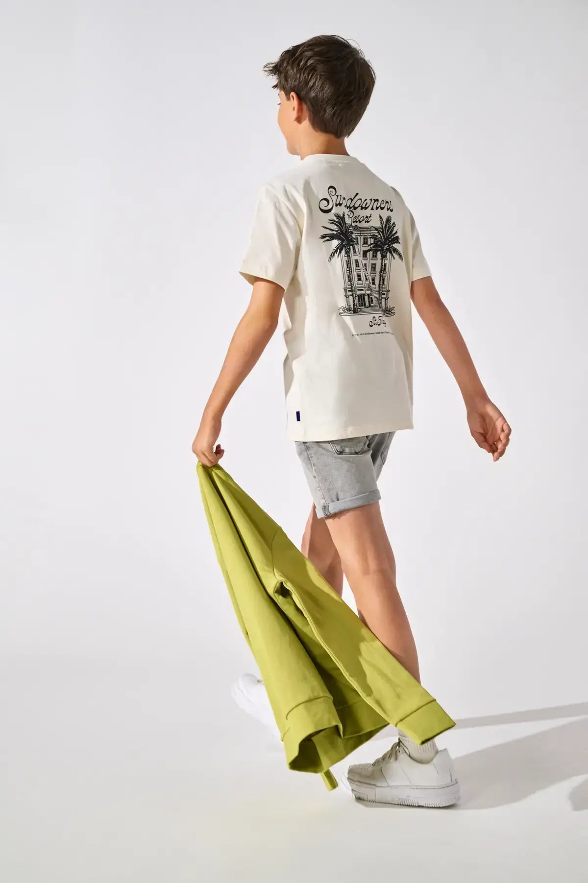 Kids Only & Sons JUNO Off White Shirt featured on a child walking with a green jacket.