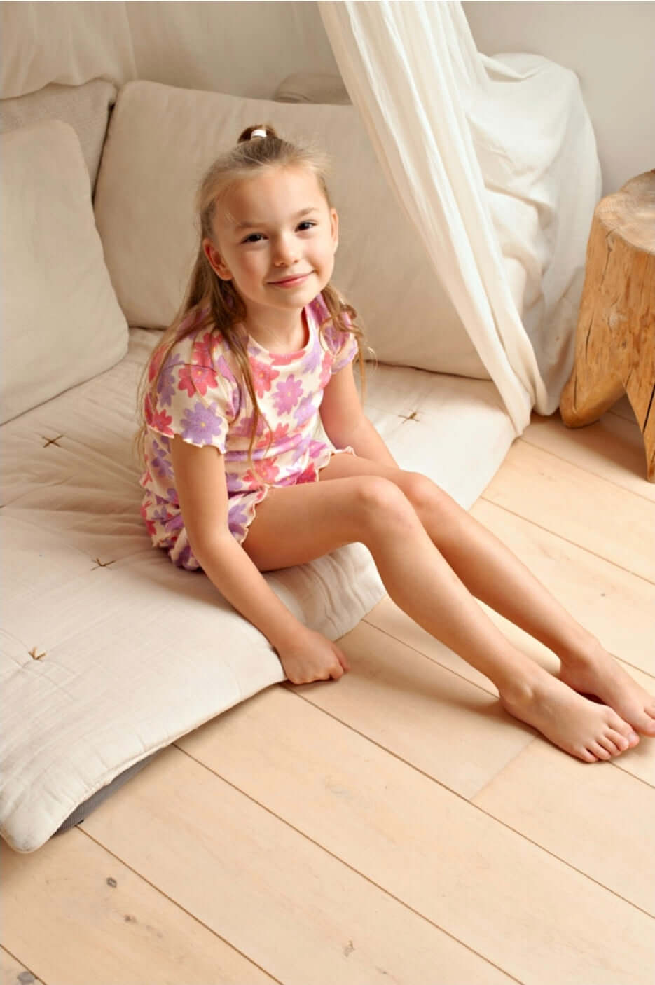 Meisje zit op een kussen in Feetje Premium Summerwear, BIBI BLOOM - premium zomerkleding voor kinderen.