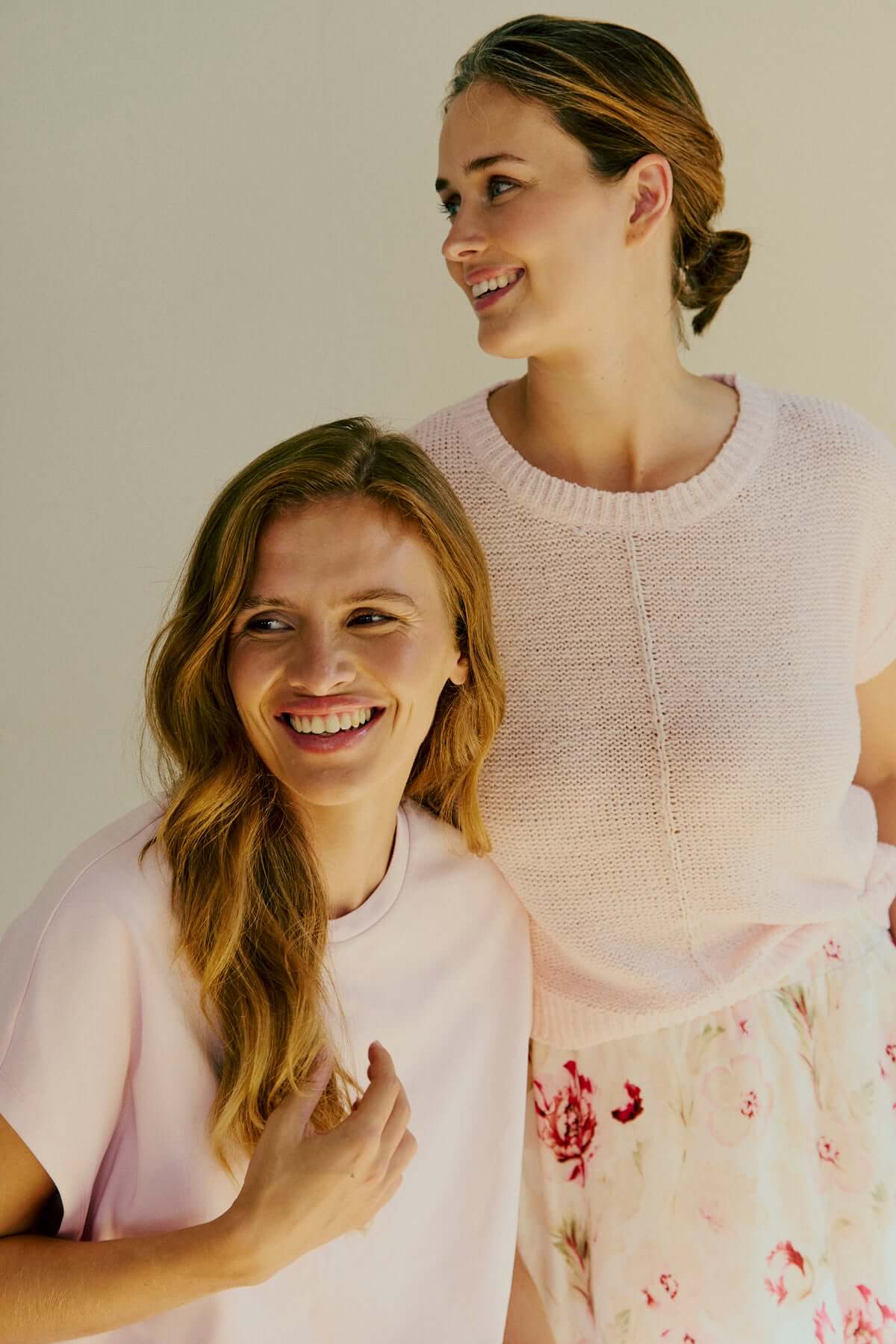 Mouwloos fuchsia t-shirt gedragen door twee vrouwen met een blije uitstraling.
